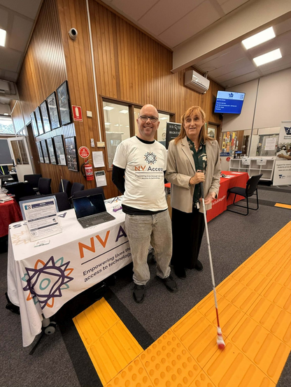 Quentin (NV Access) and Elise )Data Australasia) in front of the NV Access table at SVRC.  Elise is trying a new Sensaball cane tip.  Photo courtesy Elise Lonsdale