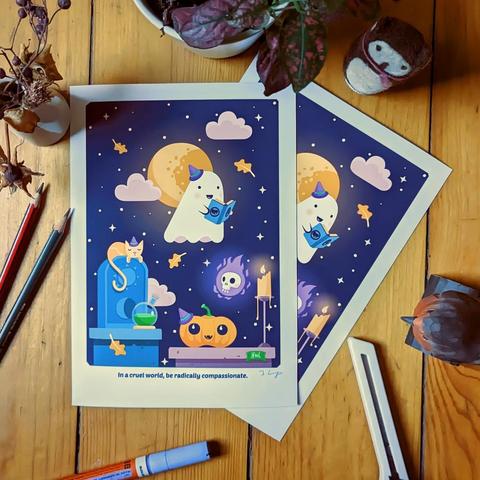 Two prints on a wooden floor surrounded by pens, flowers, a wooden bird etc. The print shows a ghost at night in a cemetery reading of a book with the anarchism and anarchy symbols to their friends: a flaming skull, a cat and a pumpkin.