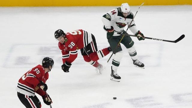 Nov 26, 2025; Chicago, Illinois, USA; Minnesota Wild center Joel Eriksson Ek (14) checks Chicago Blackhawks center Connor Bedard (98) during the third period at United Center. Mandatory Credit: David Banks-Imagn Images