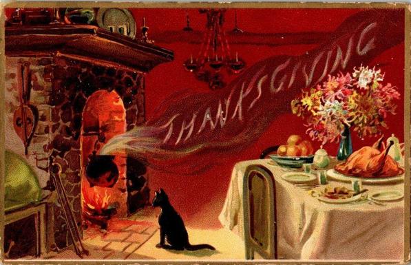 This vintage Thanksgiving postcard depicts a cozy, nostalgic interior scene glowing with warmth. On the left, a stone fireplace burns brightly, its flames heating a large black pot suspended over the fire. A small black cat sits attentively in front of the hearth, watching as smoke drifts upward and magically curls across the room to spell the word “THANKSGIVING” in soft, wispy letters. To the right, a festive holiday table is set with a roasted turkey, fruit, dishes, and a vibrant bouquet of autumn flowers in a tall vase. The deep red background and rich, painterly details evoke the charm of early 20th-century holiday imagery, blending hominess, whimsy, and celebration into a single warm scene.