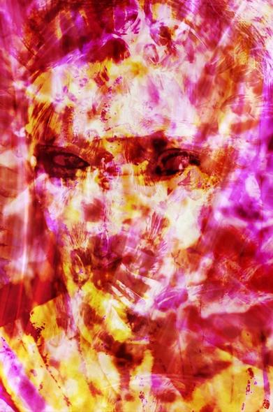 Color photograph in shades of red, orange, and yellow, portrait format, motion-blurred, multiple-exposure self-portrait (headshot). The person's vaguely recognizable face comes alive through their eyes, which gaze intensely at the viewer. Everything else dissolves, its visual impact refracted by exposures of spider legs, contrails, and plant parts. The colors, exclusively in the yellow to red range, underscore both the fleeting, fiery quality and the intensity of the person. They dissolve—into an intense flavor like heavily sweetened espresso.