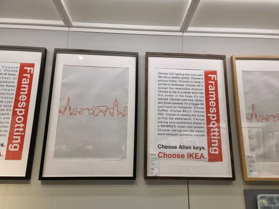 Display of an IKEA frame with the text "Framespotting. Choose LED lighting that turns your life into a catalog spread. Choose a picture frame. Choose to hang it portrait or landscape. Choose not to accept the impossible mission. Choose to slip in a swear word into this poster in the hope it's not noticed. Choose cushions, lamps, and throw blankets for a hygge life you'll post on Instagram. Choose Coffee. Choose BILLY. Choose PAX. Choose re-reading this trying to find the swearword. Choose storing your existential dread in a BRIMNES under-bed drawer. Choose taking out the swear word because someone noticed. Choose Allen keys. Choose IKEA." Beside another frame with the silhouette if Edinburgh.