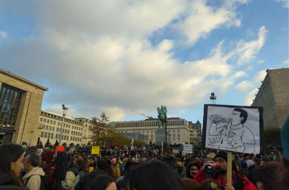 People on a large square holding up protest signs