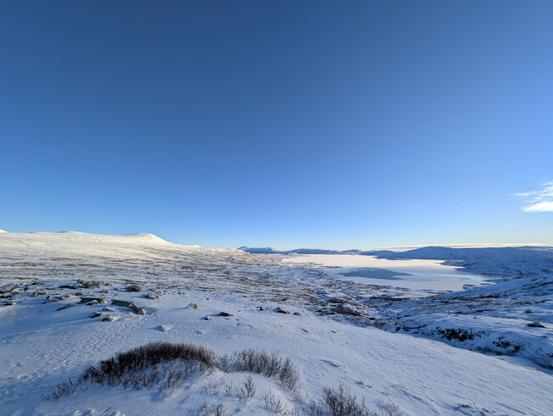 Snowy mountain plateau landscaoe with a fully blue sky.