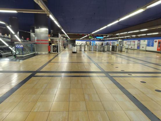 Estación de metro. Se ve un robot limpiador al fondo fregando.