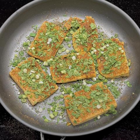 The tofu pieces in the frying pan.