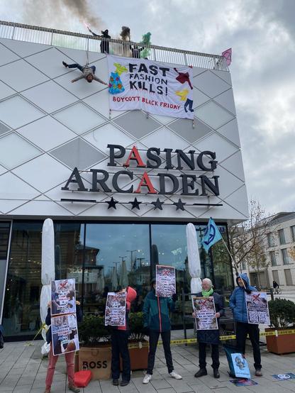 Ein Banner, von der Dachkante der Pasing Arcaden herabgelassen: "Fast Fashion kills! Boycott Black Friday"