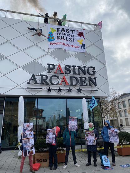 Ein Banner, von der Dachkante der Pasing Arcaden herabgelassen: "Fast Fashion kills! Boycott Black Friday"