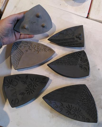 6 porte-savons de tailles différentes. Tous de forme triangulaire. 3 petits pieds pour les surélever. Sur chacun une décoration différentes avec des fleurs, des gravures, du lettrage, des symboles bretons...