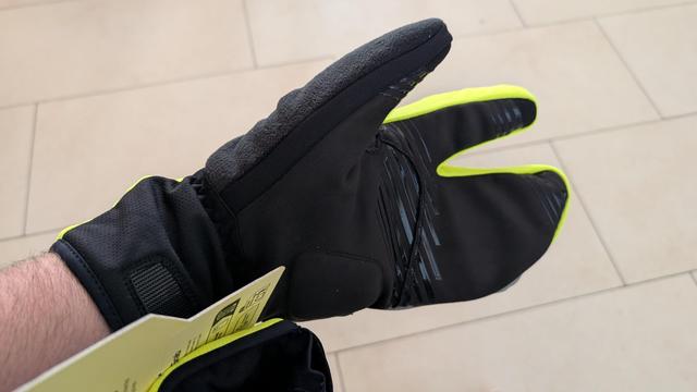 Photo of the underside of claw-looking glove, all black with some padding.
