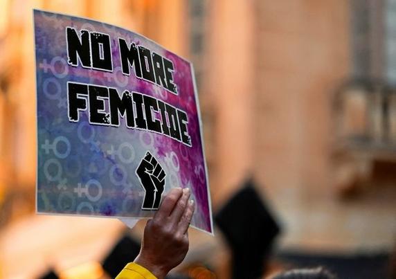 Person hält ein Plakat mit der Aufschrift: "No more femicide" in die Höhe