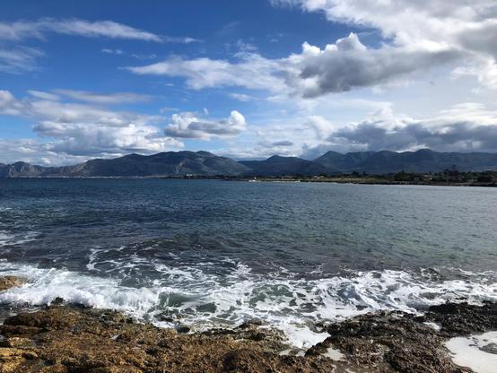 Una giornata qualunque in quest'autunno novembrile, quando la natura dà il più bel spettacolo di sé stessa. Non più il cielo terso scolorito dall'afa e il mare immobile, non più i colori sbiaditi da un sole atroce che non abbronza ma brucia. Ora la luce è tagliente, accende i contrasti tra il blu profondo del mare e il giallo del calcare della scogliera; il cielo, denso di nuvole in corsa, disegna ombre su un mare risvegliato da un lungo sonno, che respira forte contro le rocce nell’attimo in cui un’onda si infrange alta sugli scogli, come se ogni onda volesse incidere una parola sul bordo delle pietre. A tratti il vento si alza, increspa la superficie dell’acqua; nelle pozze tra gli scogli resta una schiuma sottile, memoria effimera del passaggio delle onde. Più che semplici vedute, queste immagini sono punti di ascolto: invitano a sentire il rumore del mare, il fruscio del vento, il peso delle storie non dette che abitano ancora le pietre di questo che fu un ameno luogo, perché la fotografia è bugiarda, ti consegna solo l’imbeccata del fotografo. Basta spostare di poco lo sguardo e il quadro cambia. Alla mia destra la lunga striscia d’asfalto della bretella per l’aeroporto taglia il territorio con il suo flusso continuo di auto. Alle mie spalle il complesso della “Tonnara dell’Ursa” veglia su questo teatro naturale come un’antica sentinella di pietra, ponte silenzioso tra ieri e oggi. Dietro ancora, la fila di muri, recinzioni e case sul demanio continua a raccontare una st