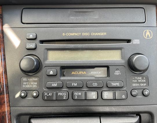 Close-up on an in-dash car AM/FM, casette, and 6-disc CD changer with both Acura and Bose branding printed on it.