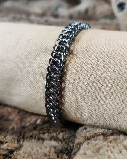 Bracelet en maille composé d'anneaux en aluminium, couleur métal foncé.