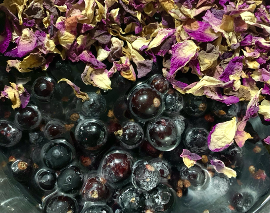 Schwarze Johannisbeeren mit Duftrosenblättern im Topf, für die Farbe und den Geschmack von Fruchtmus, vor allem aus den letzten Äpfeln.