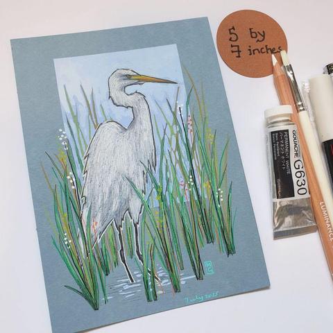 A small drawing of a Great White Egret bird standing in water with long grasses. A white heron like bird with black feet and legs and a yellow beak. The drawing is on light blue pastel paper.
What was once a very rare bird in Britain and Ireland, the Great White Egret can now be seen throughout the year, often in association with other herons.
An original art work, please note that the frame is not included.
Colour pencil and mixed media on acid free toned artist paper
5 by 7 inches (12.7 by 17.8 cm).