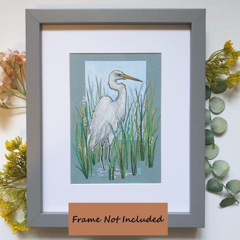 A small drawing of a Great White Egret bird standing in water with long grasses. A white heron like bird with black feet and legs and a yellow beak. The drawing is on light blue pastel paper.
What was once a very rare bird in Britain and Ireland, the Great White Egret can now be seen throughout the year, often in association with other herons.
An original art work, please note that the frame is not included.
Colour pencil and mixed media on acid free toned artist paper
5 by 7 inches (12.7 by 17.8 cm).