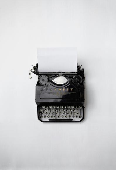 An old school black typewriter on a white background.