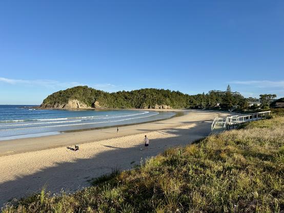 Evening light on the sands of Matapouri Beach under a blue sky