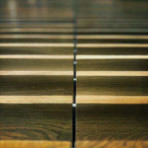 Horizontal wooden slats, with a slit through them down the middle, ascend up into the distance.
