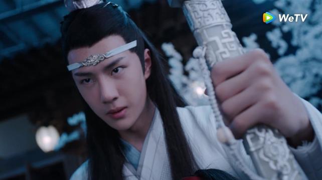 Close in shot of a resolute, angry Lan Wangji with his left hand tightly clenched around the sheath of his sword Bichen in the foreground.