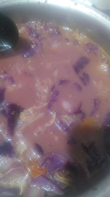 A big pot with a pink curry, showing bits of red cabbage floating in it.