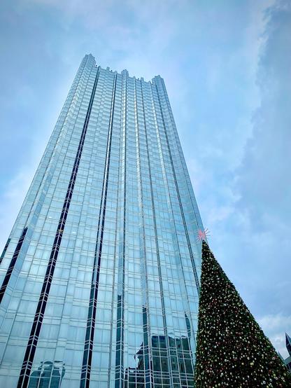 Color image of PPG Place, office tower, Pittsburgh, Pennsylvania, USA. Image shows the glass-covered office tower in downtown Pittsburgh, Pennsylvania against a blue sky with high clouds, an angular Christmas holiday tree standing at its base.