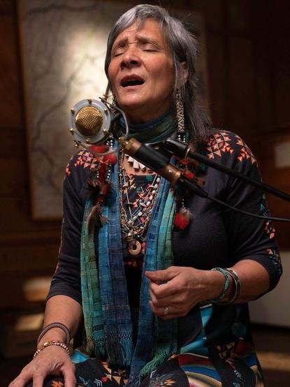 Native American vocalist and lap steel guitarist Pura Fé sings at a microphone on the set of My Music with Rhiannon Giddens.