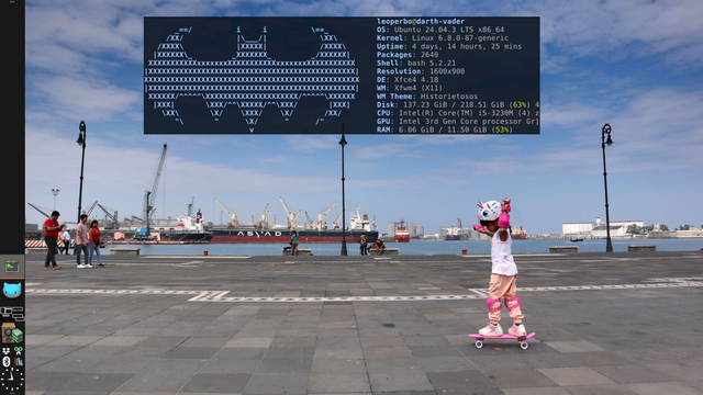 En la captura de pantalla se observa un entorno de escritorio XFCE con un panel lateral izquierdo organizado en forma de totem vertical. El panel en color carbón semitransparente muestra iconos apilados de arriba hacia abajo: una ventana de terminal, el dibujo kawai de un gato azul, un paginador de 4 escritorios con ventanas dibujadas de forma lineal, un control de volumen simbolizado con una bocina setentera, la bandeja de sistema con iconos miniatura de Dropbox, CopyQ, Bluetooth y Calibre colocados dos sobre dos y un rel reloj analógico en la base.
En el fondo, la imagen muestra un espacio abierto junto al mar, con un puerto industrial al fondo, lleno de grúas y barcos, En primer plano, destaca una niña usando patineta: lleva un casco con orejas y cuernos rosados, rodilleras y coderas del mismo color, y una camiseta blanca. Su postura es dinámica, con los brazos extendidos. El ambiente es soleado, con cielo despejado y algunas personas caminando en el área.