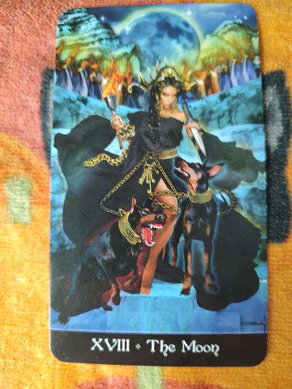 Card from the Tarot Apokalypsis deck. 
The Moon-XVIII.
A woman in dark dress, Hekate, Goddess of Witchcraft, holding a dagger on left hand and a torch on the right. She also holds two hounds by leashes. A full moon in the sky behind her.