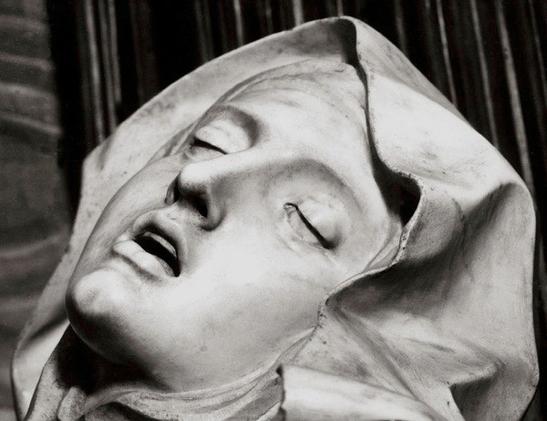 Gros plan sur le visage de la sculpture de Saint Thérèse d'Avila. Elle semble en état de transe à la manière des impressions ressentis lors d'un orgasme féminin.