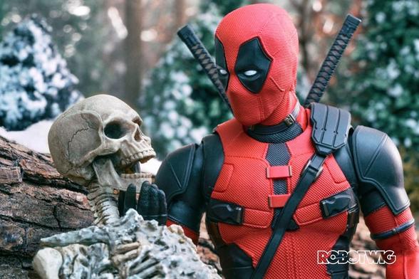 Deadpool sits next to Wolverines skeleton moving his Jaw with his hand whilst mimicking his voice. Snow and woodland in background