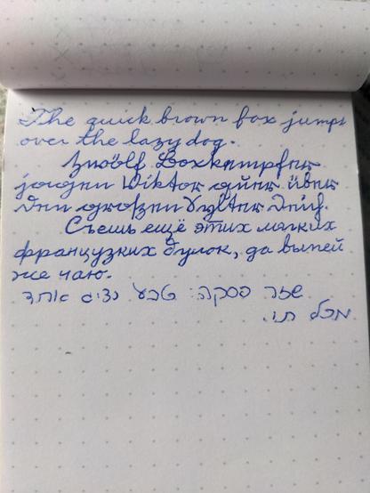 D'Nealian cursive English pangram. Old German Kurrent pangram. Russian cursive pangram. Hebrew cursive pangram. Blue ink on dotted Rhodia paper.