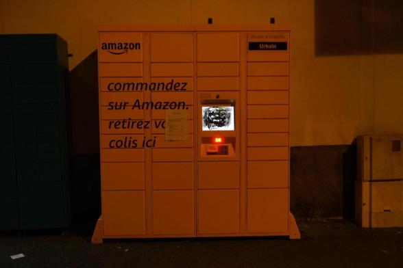 Photo d'un locker amazon la nuit. L'écran est recouvert de peinture noir.