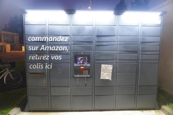 Photo d'une locker amazon la nuit. L'écran est recouvert de peinture noir.