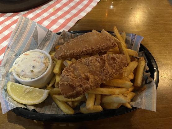 Picture of a small portion of dry looking fish and chips.