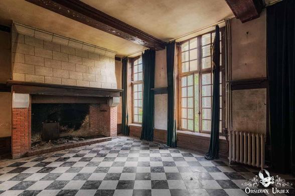 room with large fireplace and checked floor