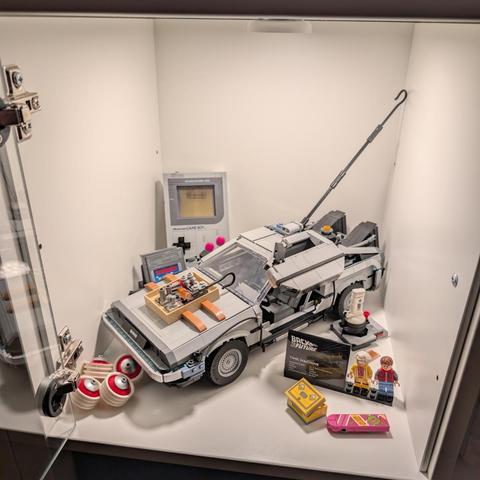 Der Lego-GameBoy und ein Lego-Modell der Zeitmaschine aus dem Film "Zurück in die Zukunft" in einem Kallax-Regalfach mit Beleuchtung