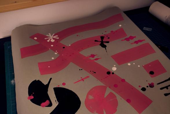 A gray piece of paper with thick red lines, black splotches on it