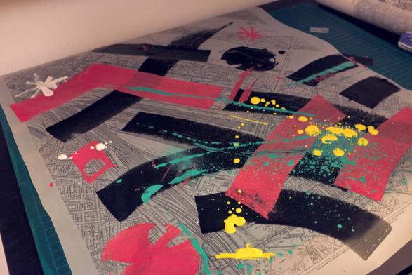 A more elaborate piece of abstract art painted on a printed transparent paper with a map. Thick red and black lines, yellow splotches and turquoise slashes