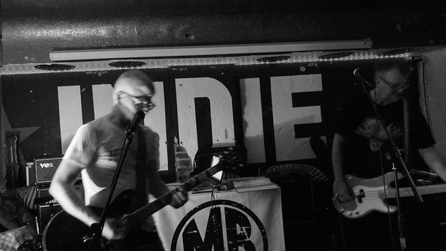 Zwei Männer spielen Bass-Gitarre und Gitarre auf der Bühne im Indie in Duisburg.