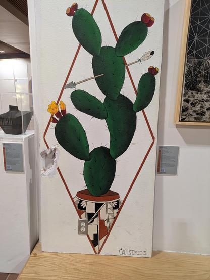 painting on wall (sheetrock) depicting a cactus in pueblo style by artist cactus eddie, removed from original location and now displayed in albuquerque sunport.