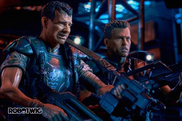 Hudson looks worried whilst looking at his motion Tracker, Hicks stands next to him holding pulse rifle