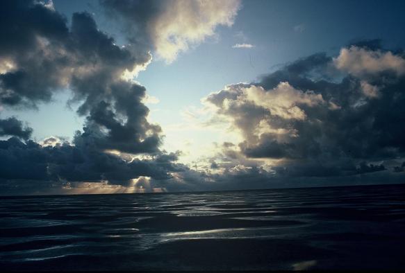 Wolkengebirge, durch das die Sonne scheint, über dem Watt