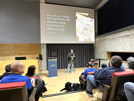Berta Nicolau a l'escenari de l'auditori de l'a11yConf 2025 a Girona parlant de disseny i accessibilitat digital davant de la audiència