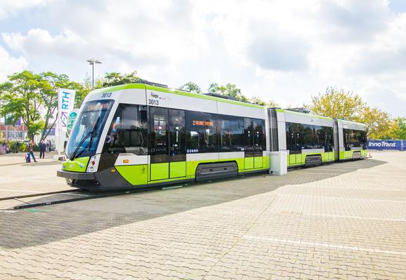Eine Straßenbahn steht auf temporären Schienen die auf eine gepflasterte Fläche gelegt wurden.