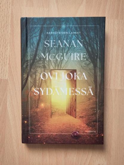 Kirjan kansi, kannessa metsää ja hailakka ovi.