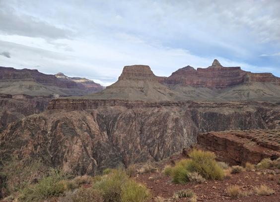 A view of a rock wall within the Grand Canyon where newer layers of horizontal sedimentary rock lie atop older, more vertically oriented metamorphic rock.