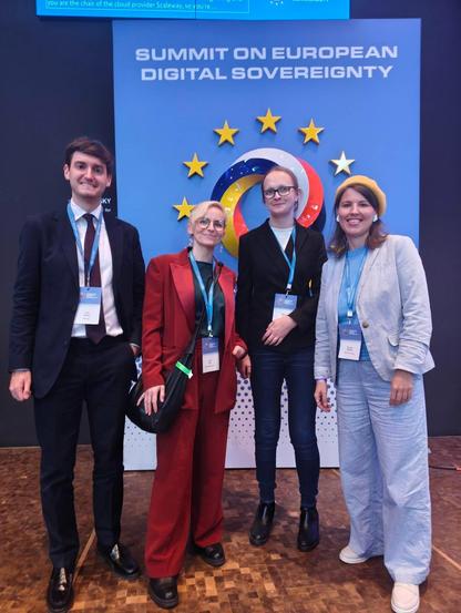 4 people standing in front of the #eusummit25 Logo.