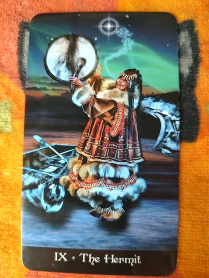 Card from the Tarot Apokalypsis deck.
The Hermit-IX.
An elder Innuit/eskimo woman in traditional garb, beating a drum as she looks up to the sky. There is a bright star above her in the sky.